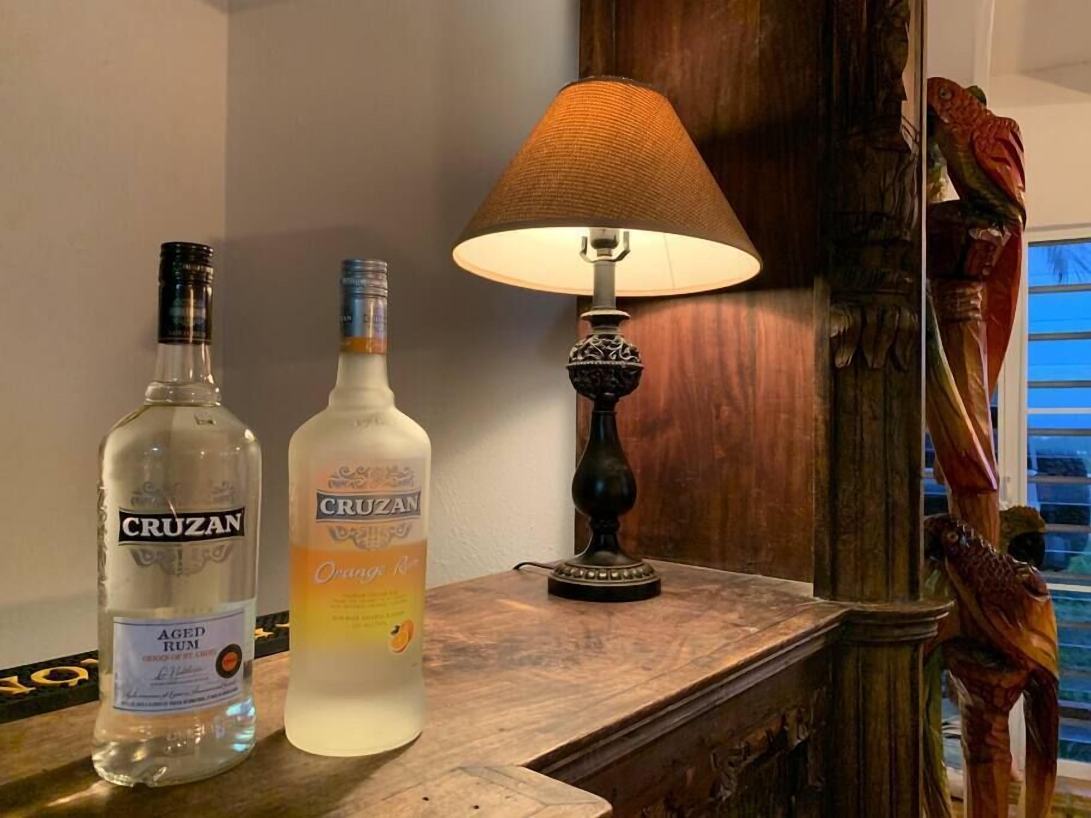 Deux bouteilles de rhum Cruzan et une lampe sur une table en bois.