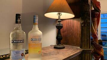 Two bottles of Cruzan rum and a lamp on a wooden table.