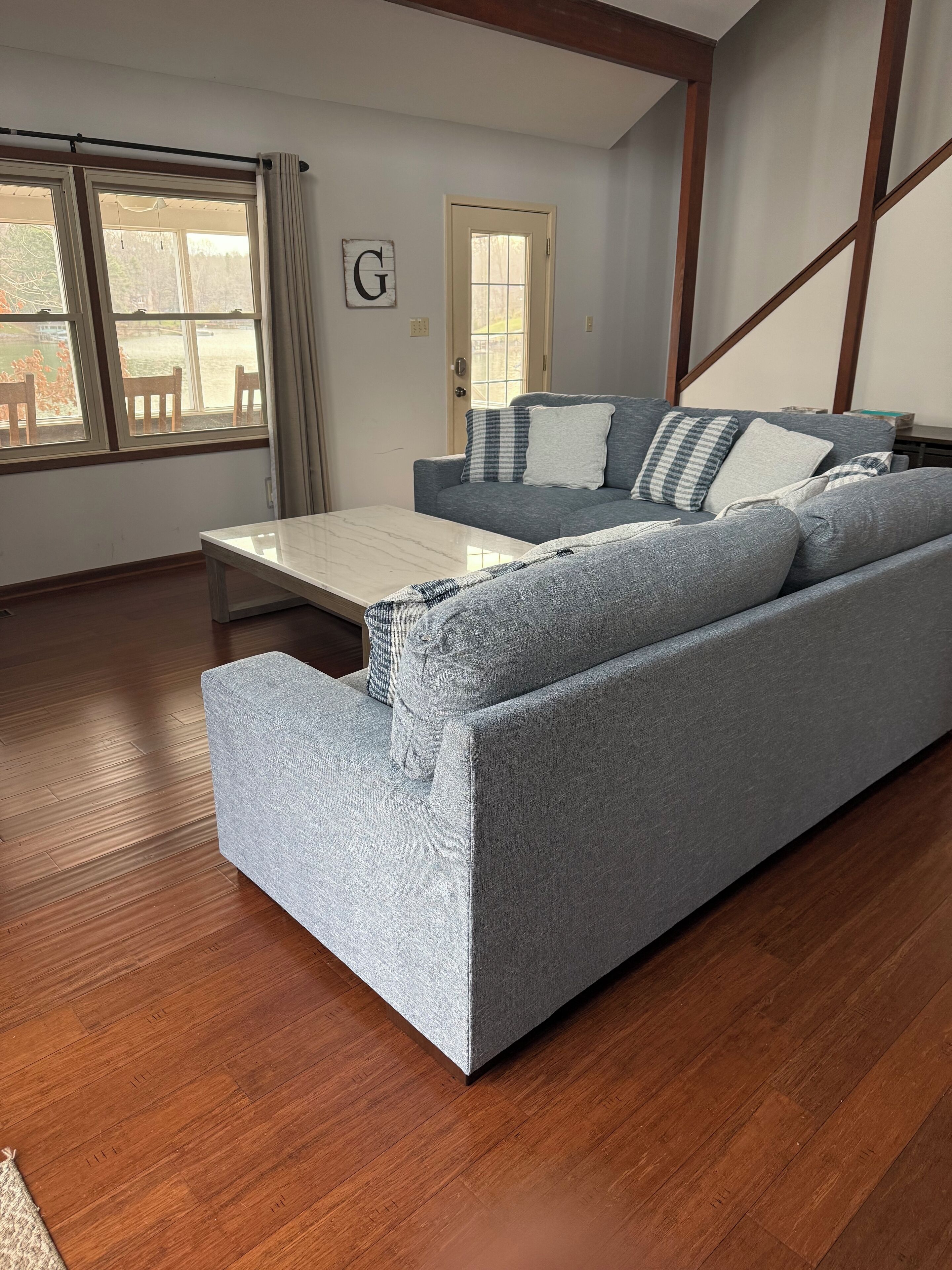 A living room with a grey sofa, a coffee table, and a wooden floor.