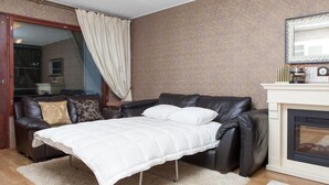 A room with a sofa bed, a fireplace, and a mirror on the wall. - Feel yourself at  Three Bears appartment :) (Kotka)