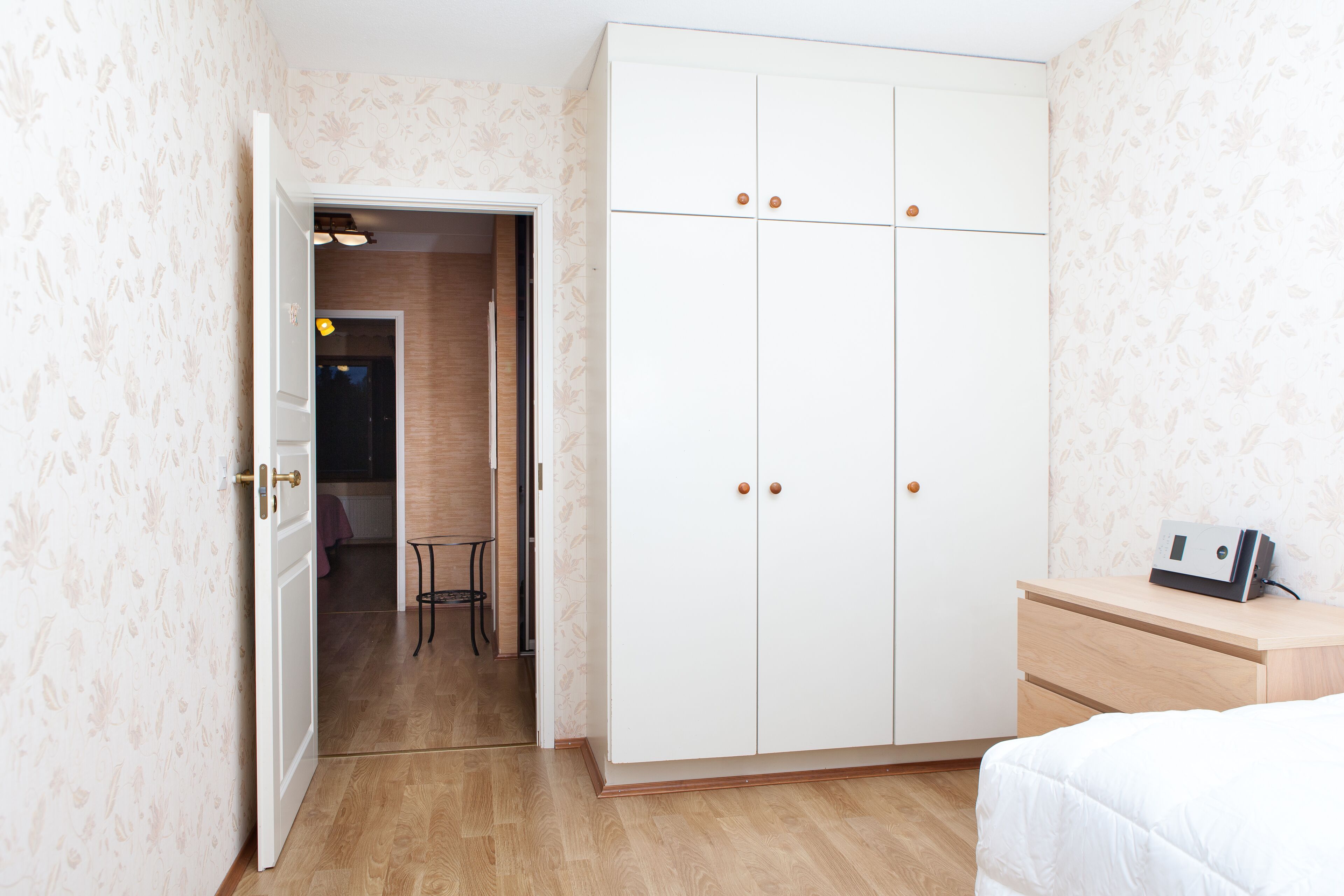 Ein Schlafzimmer mit Kleiderschrank, Nachttisch und Stuhl.