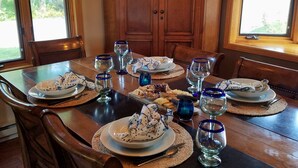 A dining table set with plates, glasses, and cutlery, surrounded by wooden chairs. - Luxery Waterfront Oasis  4bd 5minutes from the Jackson Town Square & Whole Foods (Jackson)