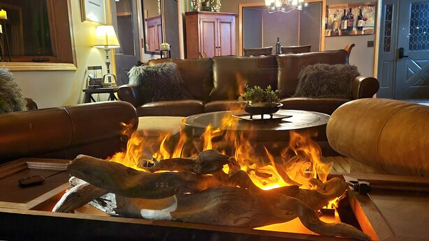A cozy living room with a fireplace, leather sofas, a coffee table, and a lamp. - Luxery Waterfront Oasis  4bd 5minutes from the Jackson Town Square & Whole Foods (Jackson)