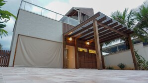 Um edifício moderno com entrada coberta, garagem e varanda.