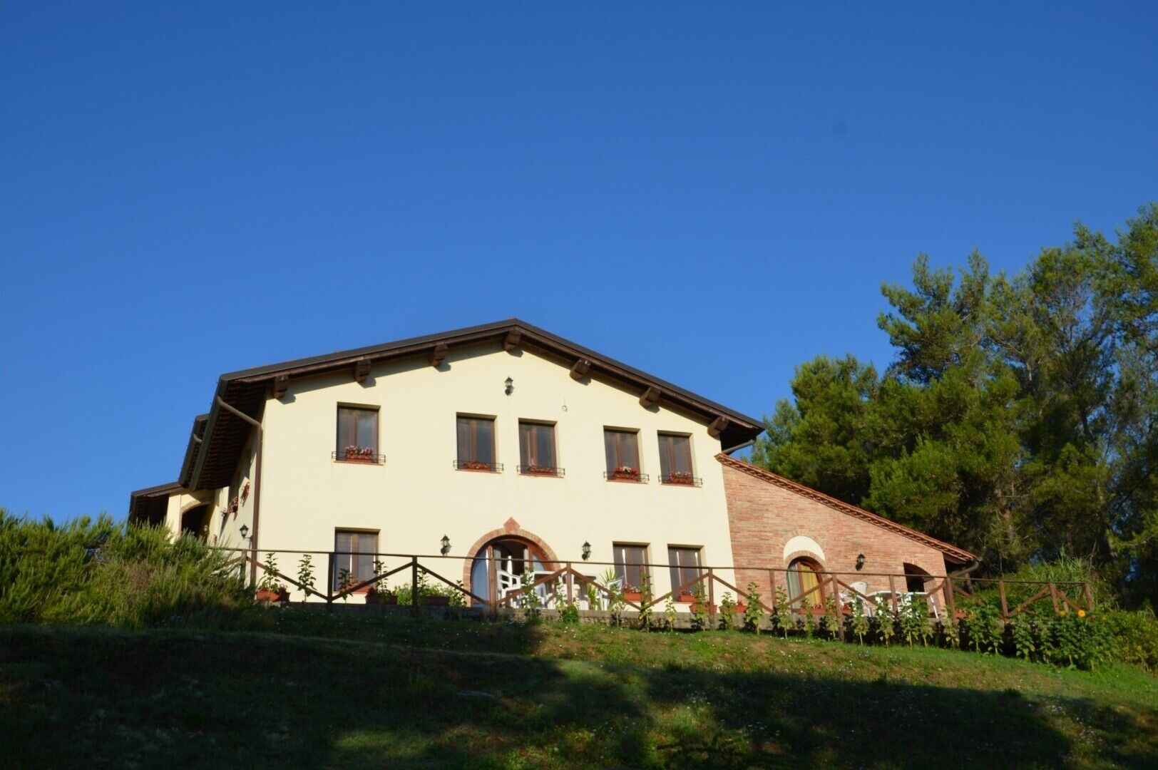 A two-story building with a flat roof, multiple windows, and a small porch area.