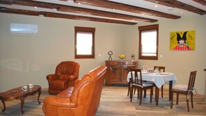 Un coin repas avec une table en bois dressée pour quatre personnes, entourée de chaises en bois.