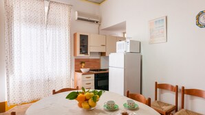 Eine kleine Küche mit Kühlschrank, Herd und Holzschränken.