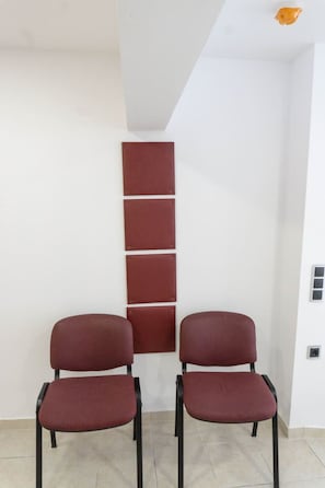 A room with two chairs and a wall-mounted panel.
