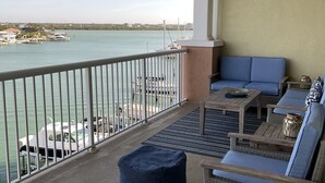 Ein Balkon mit Blick aufs Wasser, Deckenventilator und Gartenmöbel.