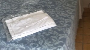 Una cama individual con una colcha estampada y dos almohadas.