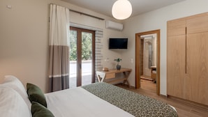 Une chambre moderne avec un grand lit, un bureau et une télévision.
