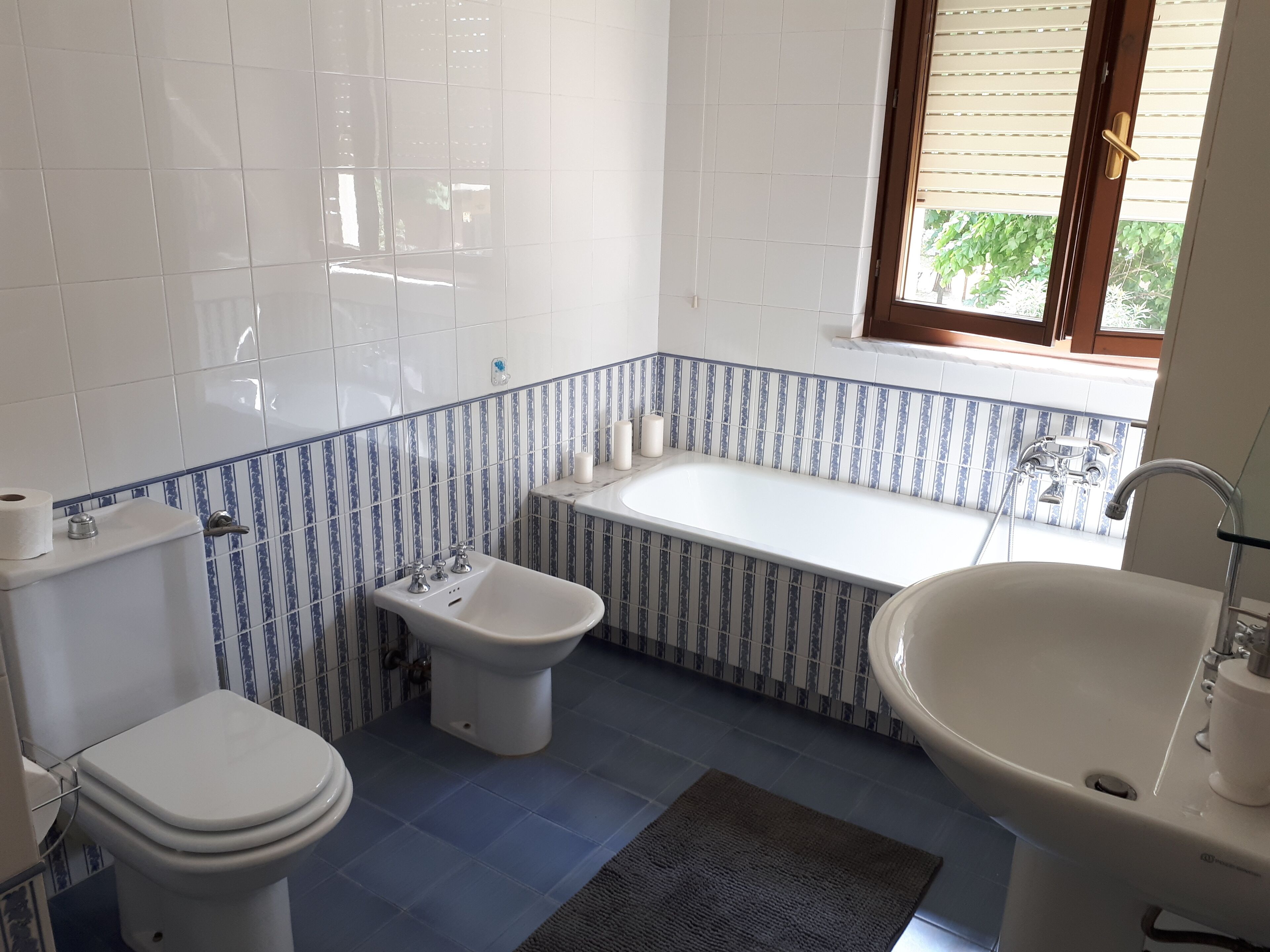A bathroom with a toilet, bidet, bathtub, and sink.