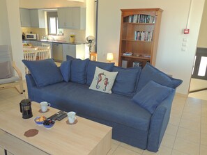 Un salon avec un canapé, une table basse et une bibliothèque.