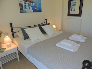 A neatly made bed with pillows, a bedside lamp, and a folded towel on the nightstand. - A Recently Refurbed 3 Bedrm Villa, Large Pool, Great Privacy, Close to Amenities (Chania)