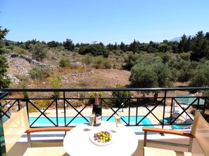 Un balcon avec une table, une bouteille de vin et un verre de vin.