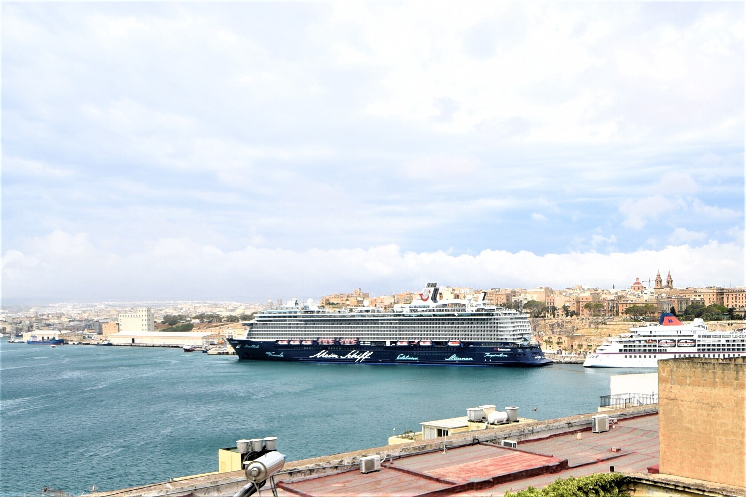Un grand navire de croisière était amarré dans un port, avec une vue sur la ville en arrière-plan.