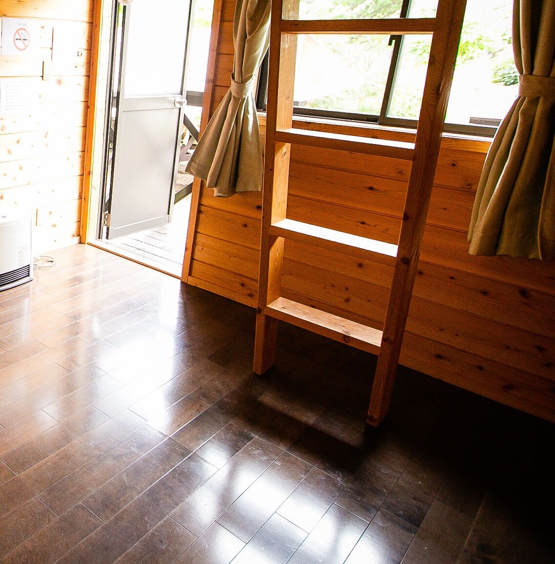 Un interior de madera con un banco, una puerta corredera y una ventana.