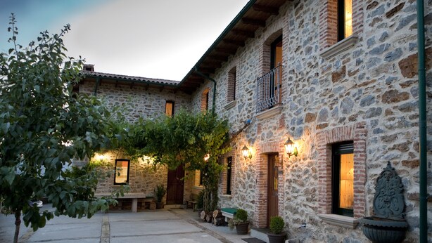 A stone building with a courtyard, potted plants, and outdoor seating. - La Majada de Peñacorada I C.R Ideal with children in the foothills of Picos de Europa (Fuentes de Peñacorada)
