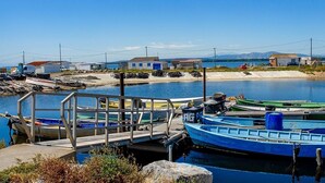 A dock with several boats, a small pier, and a clear view of the surrounding buildings and landscape. - Studio Gruissan plage wifi piscine, clim, parking, équipée 4 pers, RDC, terrasse sud (Gruissan Plage)