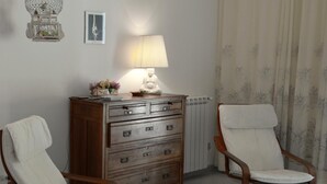 A room with a wooden dresser, a lamp, a chair, and a radiator. - ATRANI "Pompeo" AMALFI COAST (ATRANI)