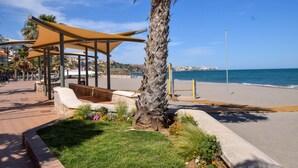 A beachside promenade with a covered seating area, palm trees, and a view of the sea. - Ref: 237 Beachfront apartment in Carvajal with amazing sea views (Fuengirola)
