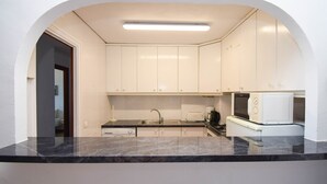 A modern kitchen with white cabinets, a black countertop, and a built-in microwave. - Ref: 237 Beachfront apartment in Carvajal with amazing sea views (Fuengirola)