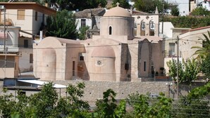 Un edificio histórico con múltiples cúpulas y fachada de piedra, rodeado de edificios residenciales.