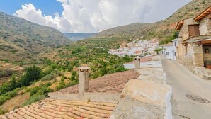 A hillside village with stone buildings and terraced roofs.