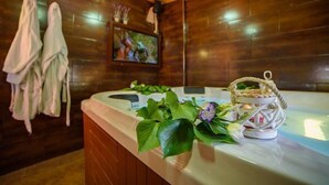 A spa room with a wooden wall, a massage table, and a TV screen.