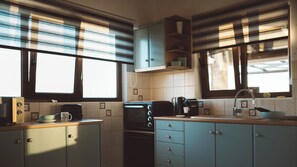 A kitchen with a microwave, toaster, coffee maker, and cabinets.