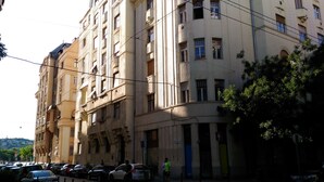 Un immeuble à plusieurs étages de style architectural classique, doté de grandes fenêtres et d’une entrée centrale.
