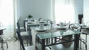 A dining area with tables set for multiple people, featuring glass tops and metal frames. - NASONI DI ROMA COLOSSEUM APPARTAMENT  (until 33 people) (Roma)