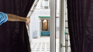 A person opening a door to a room with a bed and a small table. - NASONI DI ROMA COLOSSEUM APPARTAMENT  (until 33 people) (Roma)
