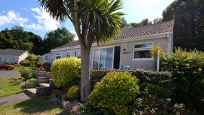 A single-story house with a tiled roof, a front door, and a small porch. - Gower, Oxwich, Amazing Views, Sleeps 4 (Oxwich)