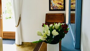 A reception area with a vase of flowers, a framed picture, and a wooden bench. - La Blatière Farmhouse-pool, sauna&gym-games room.Rural setting close to it all.  (La Chapelle- Saint-Etienne)