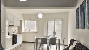 Un appartement moderne comprenant une cuisine, un coin repas et un salon.