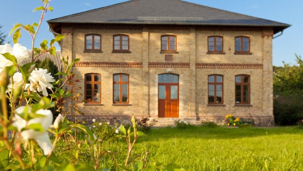 A two-story brick building with a symmetrical facade, multiple windows, and a central entrance. - Spacious and stylish in the monument to the Müritz, near the lake and golf course (Lexow)