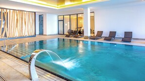 An indoor swimming pool with clear water, sun loungers, and a modern interior design. - Comfortable large suite, pool and sauna, 30 meters to the beach, large south-facing balcony (Börgerende)