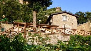 A stone building with a wooden deck and a stone wall.