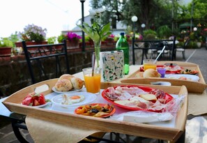 A breakfast tray with various foods and drinks on an outdoor table. - Traulivi villa with pool (Meta)