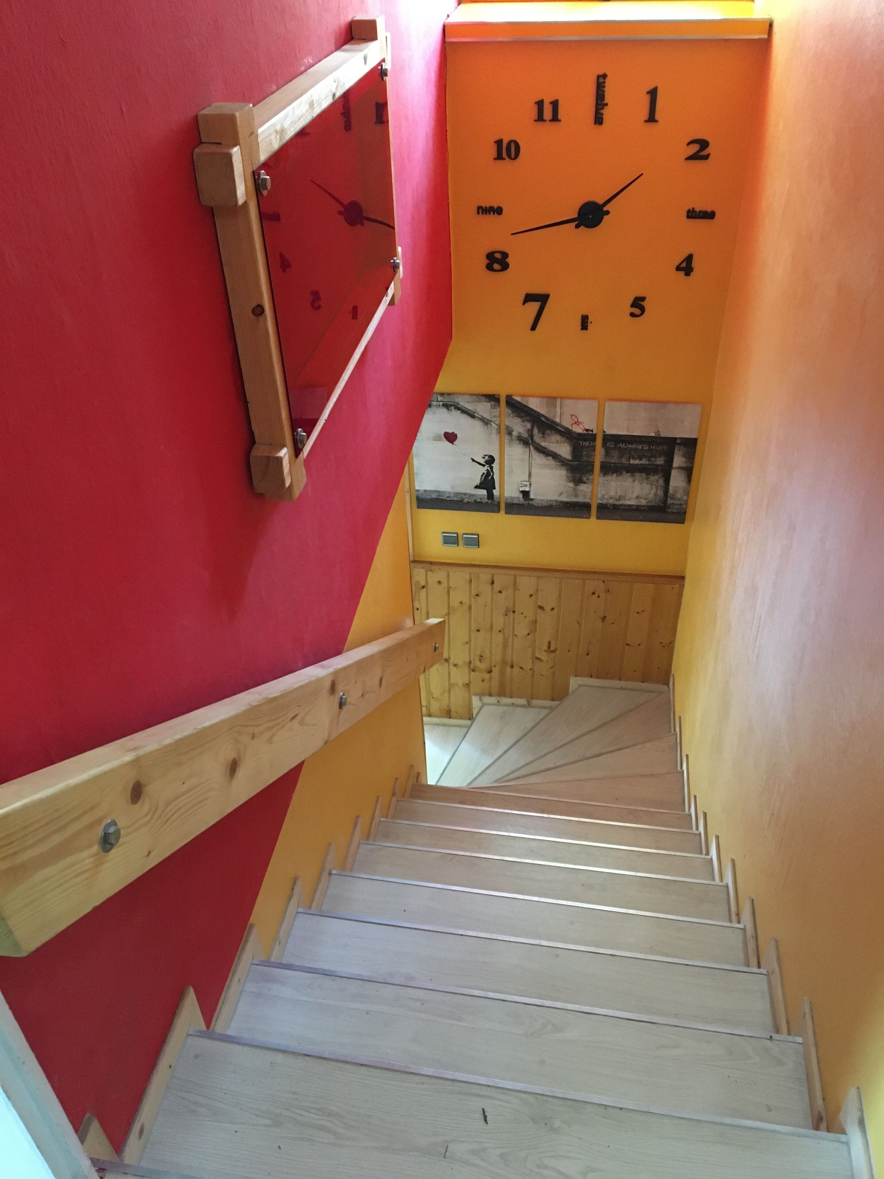 Eine Treppe mit hölzernen Geländern und einer roten Wand.