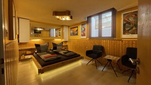 Una habitación acogedora con una cama, dos sillas, una mesita y un ventanal.