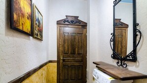 A hallway with a wooden door, a washing machine, and a mirror. - Apart-Hotel Kraft (Lviv)