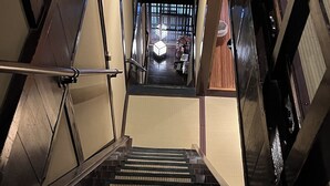 Una escalera con barandilla que lleva a un rellano con vistas a una habitación.