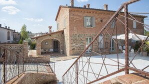 A traditional stone building with a courtyard, a staircase, and outdoor seating. - Villa Ventotto by Paola Orazioli (Arezzo)