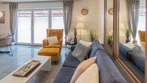 Een moderne woonkamer met een bank, fauteuil en salontafel.