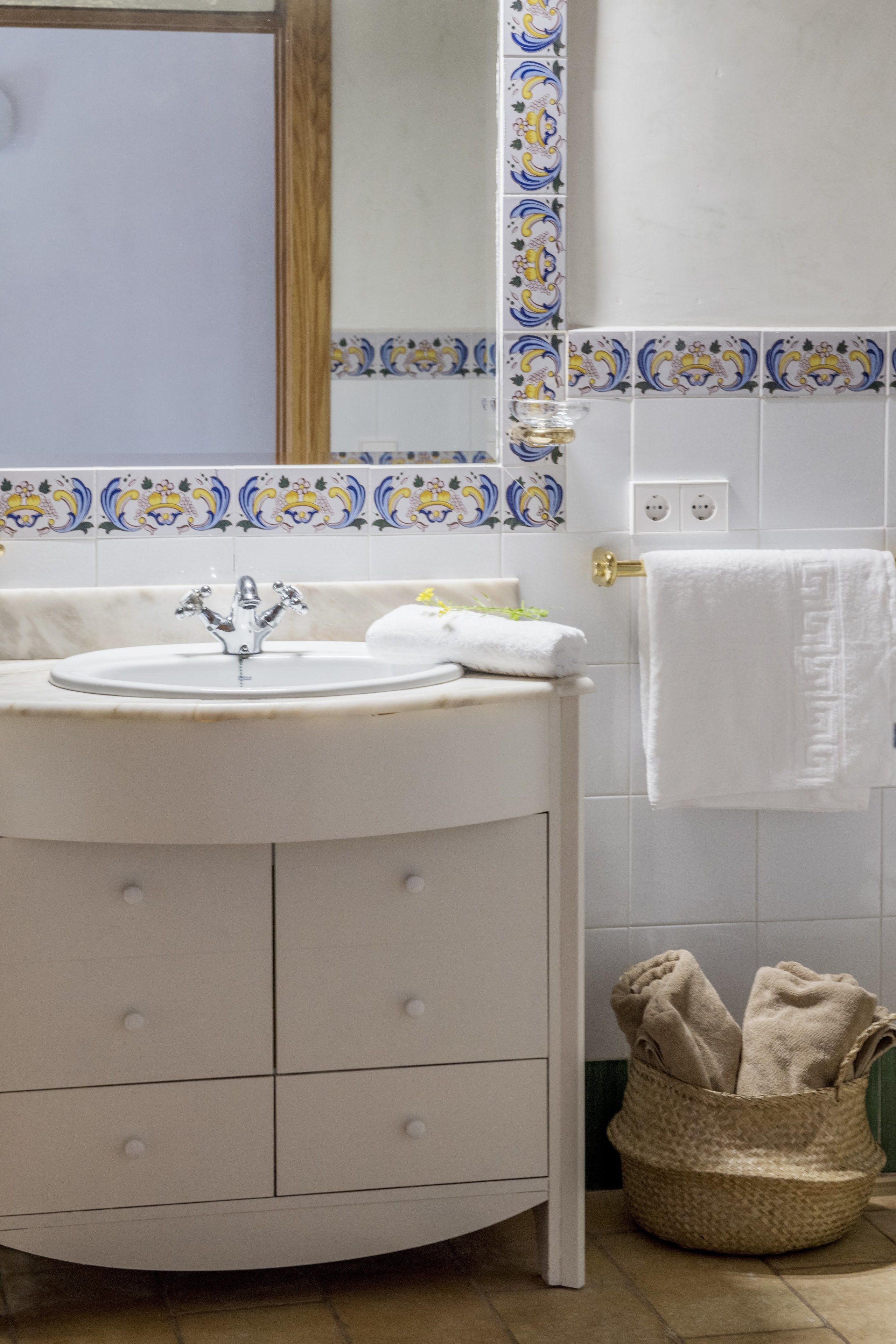 A bathroom with a white sink, a mirror, and a towel rack.