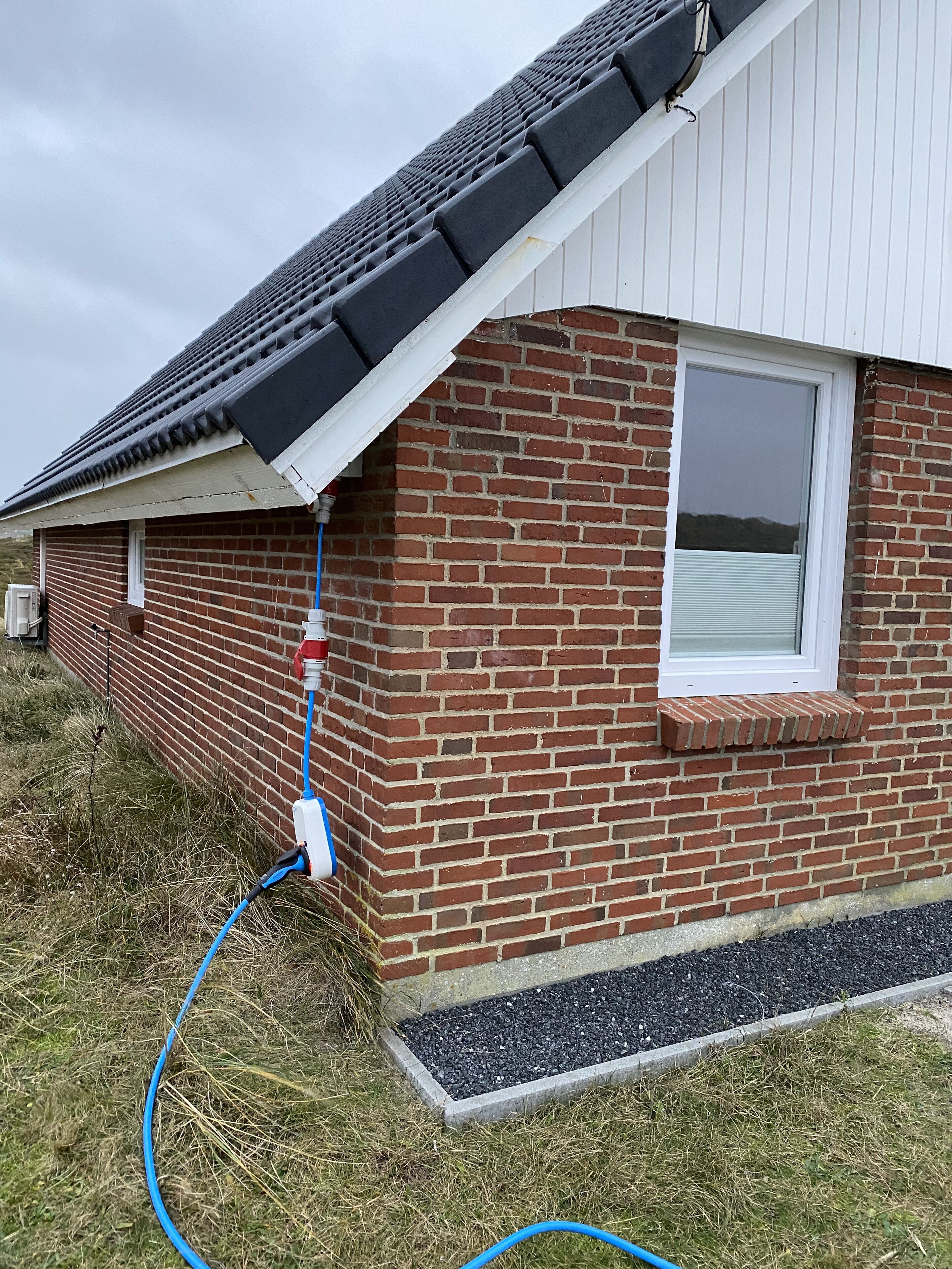 A brick house with a window and a gutter system.