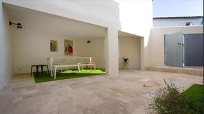 Relax in this open-plan living space with a central seating area and artificial turf for lounging or outdoor activities.