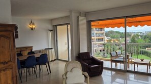 Un appartamento moderno con un balcone, un'area pranzo e un angolo salotto con vista.